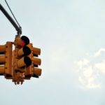 A view of a traffic signal system against a blue sky.